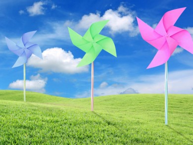 Paper toy windmill in green grass field